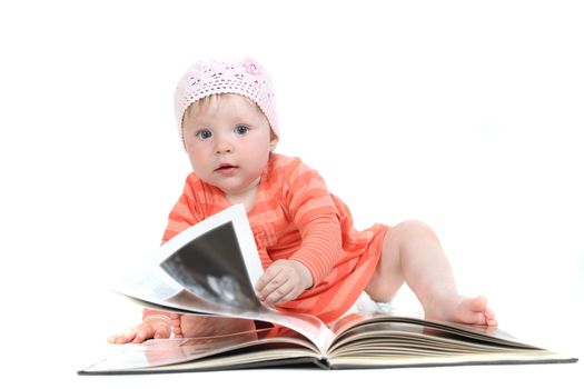 The little blue-eyed girl thumbs through the book. A portrait on a white background. Option 10