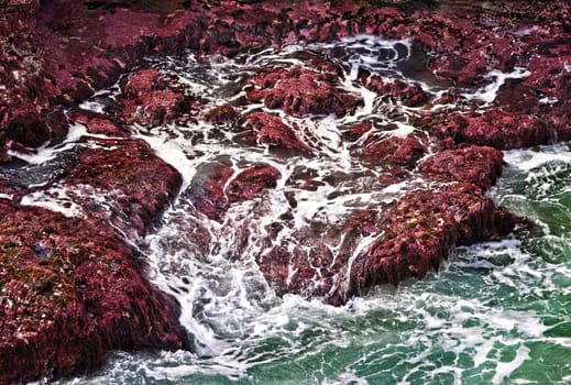 ocean waves crash on to rocks at the coast