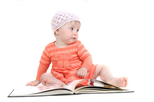 The little blue-eyed girl thumbs through the book. A portrait on a white background. Option 1.