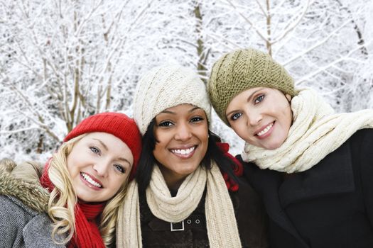 Group of three diverse young girl friends outdoors in winter