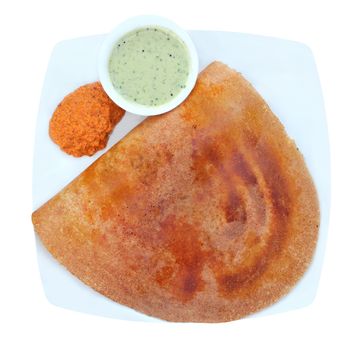 Golden masala dosa with two different chutneys on a plate isolated on white with clipping mask