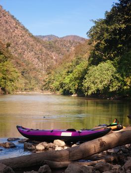 canoe on waters edge waiting for use in northern thailand