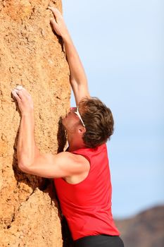 Climbing. Rock climber free climbing. Strong fit man fitness sport model hanging on vertical cliff.