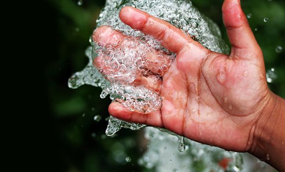 Fresh clean and pure bubbling water splashing on hand