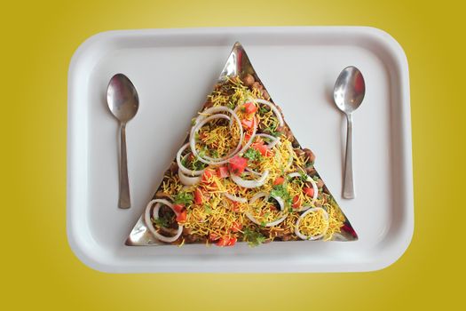 Masala or sev puri - indian chaat snack made with tangy sauce, fried bread, vegetables and fruits and sev. Image with clipping mask