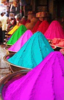 Colorful piles of finely powdered dyes used for hindu religious activities like holi on display in an indian shop at mysore market