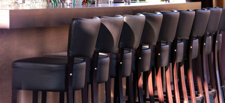 Many bar seats with leather in a row