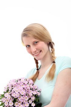 Smiling blond female holding pink flowers on white background