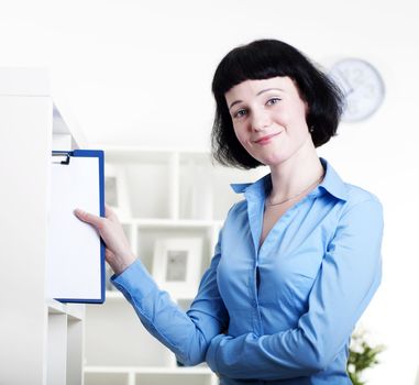 woman puts a tablet with documents in a rack for documents