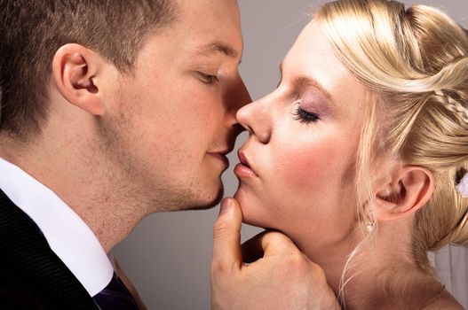 young couple in wedding wear kissing