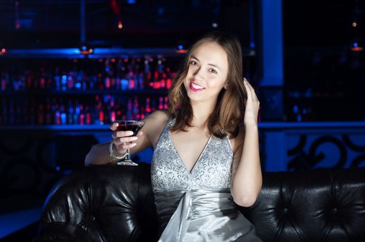 beautiful young woman, rest on Leather sofa and drinks beverage