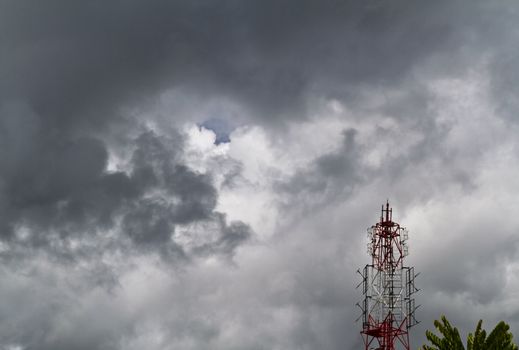 View of a radio tower against the sky with dark cloud