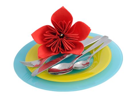 A set of cutlery on a plate with a flower from a tissue (isolated)