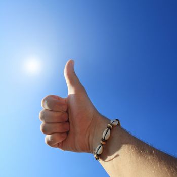men's hand make thumbs up on blue sky