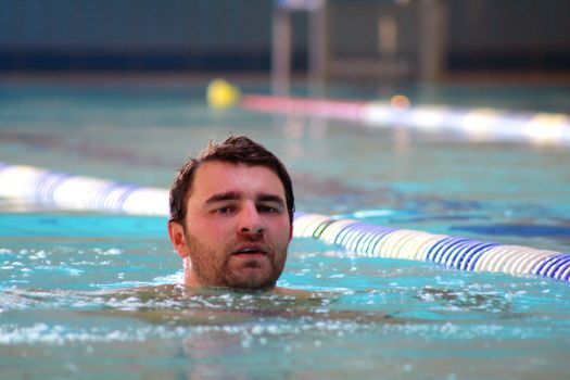 man swims in swimming pool