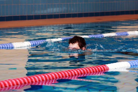 man swims in swimming pool