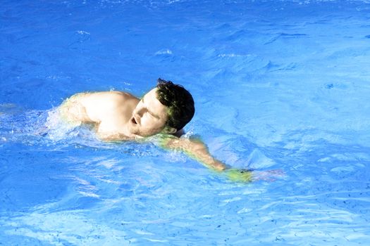 man swims in swimming pool