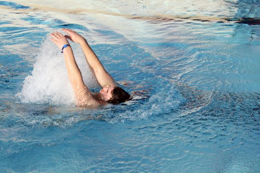 man swims in swimming pool