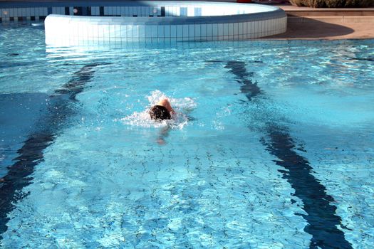 man swims in swimming pool