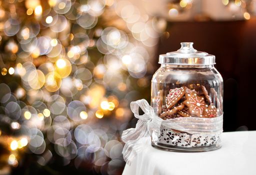Gingerbread biscuits in glass jar, fantasy Christmas background