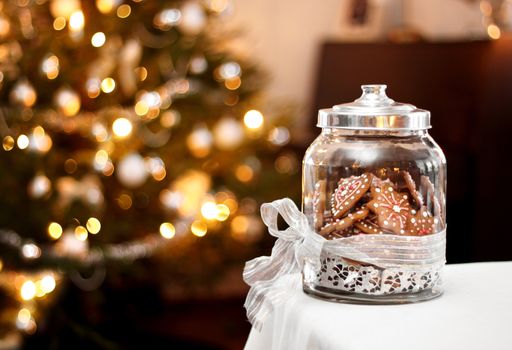 Homemade gingerbread biscuits in glass jar, Christmas background