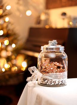 Homemade christmas gingerbread biscuits in glass jar on table
