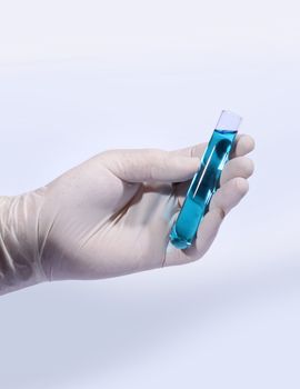 Chemist hand in protective glove holding liquid test tube