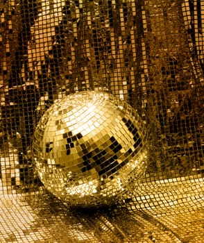 Golden disco mirror ball reflect light on glitter canvas background
