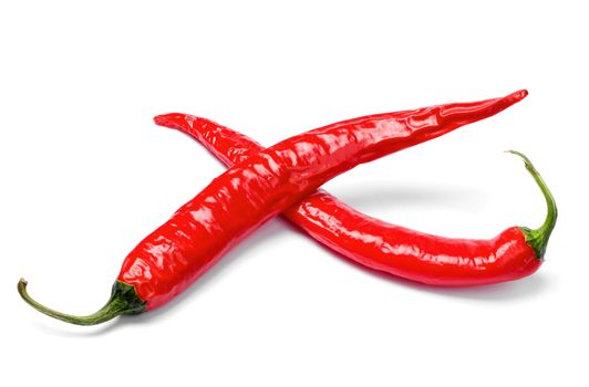 Red chili peppers cross on white background isolated