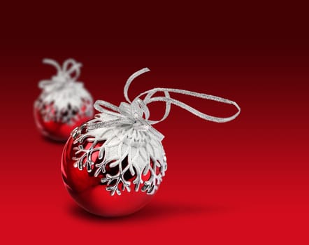 Two Christmas balls with snowflake decoration, vivid red background