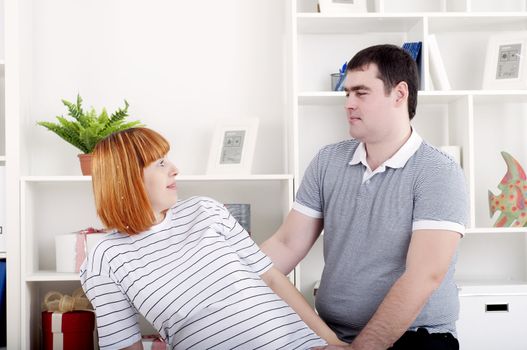 portrait of a husband and a pregnant wife at home with