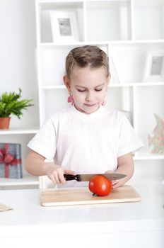 beautiful girl in the kitchen cooking vegetables