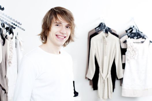 man in shop of clothes, smiles and is happy with purchases