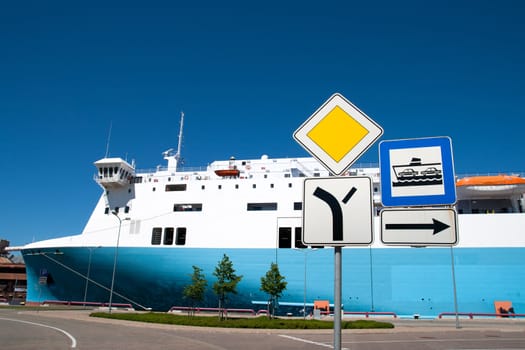 sign entry to the ferry port with a ferry in the background