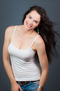 Portrait of a happy beautiful young woman, over grey background