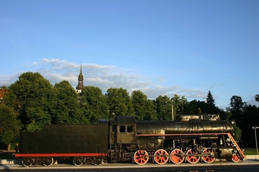 The locomotive old with the hook-on car, historical model and design, on a decline of day