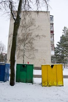 snow cover plastic bins for sorting waste. yellow blue and green with drawing in winter.