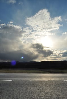 Image of sun shine through rain cloud at sunset