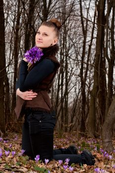 beautiful girl with snowdrops in a forest