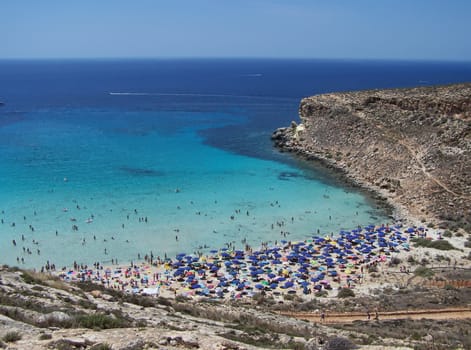 This is the magnificent island of rabbits, in Lampedusa. The water is crystal clear and the sand is white. The rocks are silhouetted against the blue sea and the sky is clear. The depths of this island are a paradise for divers because they are full of colorful fish. 
In this beach nesting turtles, who do travel miles to come to lay their eggs.  This area is protected reserves.