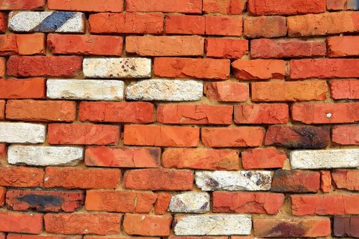 Fragment of a wall of red brick with a few bricks of white refractory silica brick