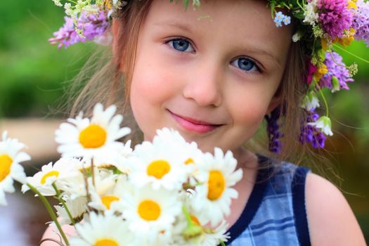 girl in the wreath with a bouquet of daisies.