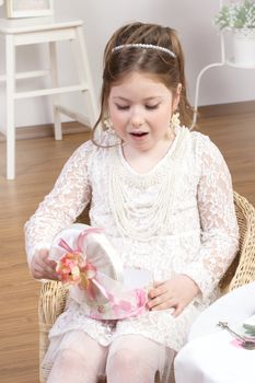 Girl looking in to gift box in white studio