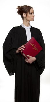 Women dress as a canadian attorney, holding a red book of criminal law with bilingual text on it