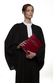 Women dress as a canadian attorney, holding a red book of criminal law with bilingual text on it