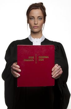 Women dress as a canadian attorney, holding a red book of criminal law, front and center, with bilingual text on it