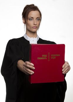Women dress as a canadian attorney, holding a red book of criminal law with bilingual text on it