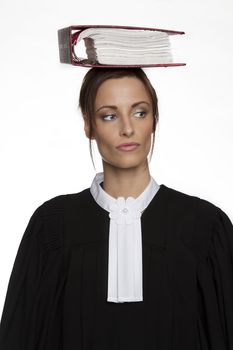 Women dress as a canadian attorney, balancing a red book of law on it on her head