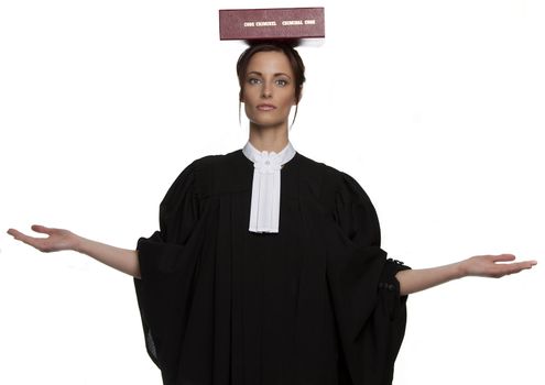 Women dress as a canadian attorney, balancing a red book of criminal law with bilingual text on it on her head