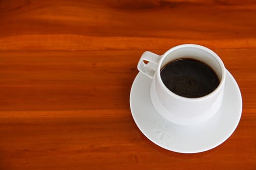 White Cup of Hot Espresso coffee on Wooden Table